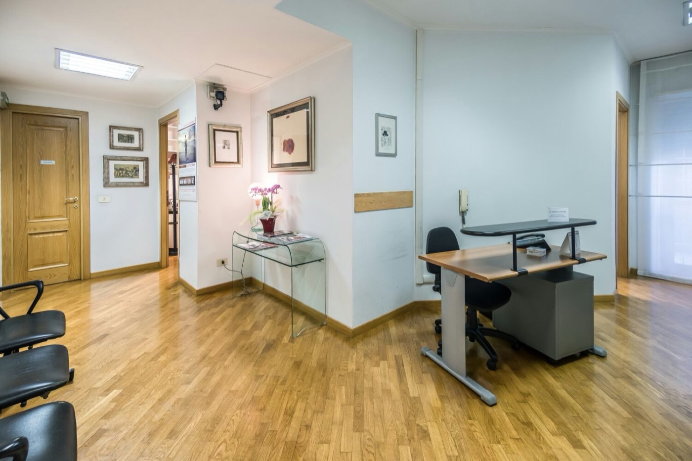 Sala dello Studio Medico Lintas con scrivania, poltrone e parquet