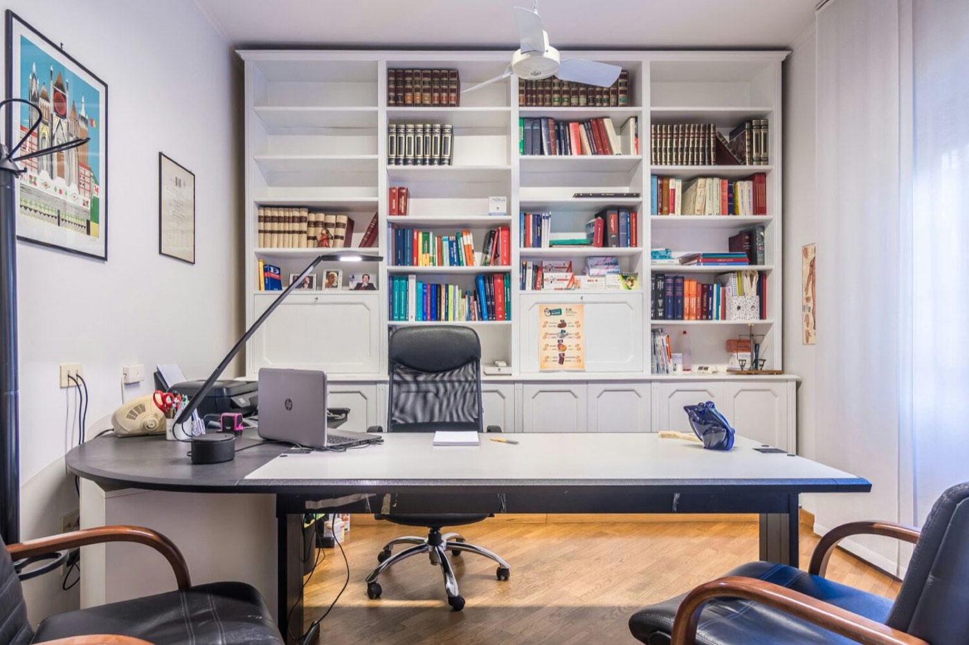 Studio del medico Lintas: scrivania e libreria con testi medici